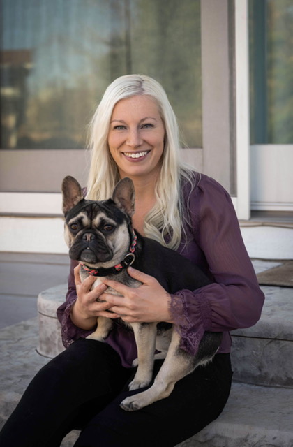 Tory Mayo, owner of Pampered Pups Grooming, holding her dog